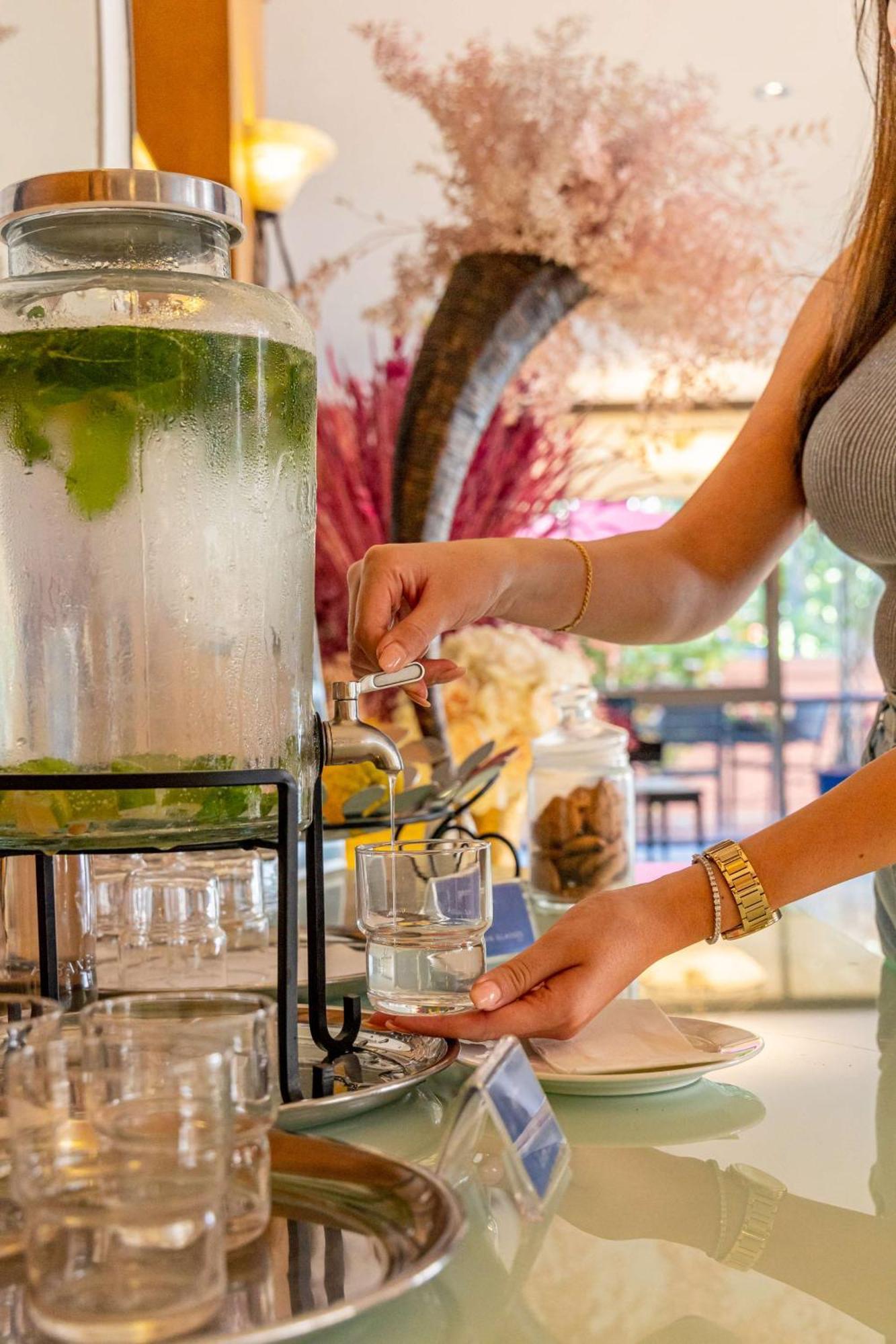Radisson Blu Martinez Beirut Hotel Bagian luar foto A woman filling a glass with a beverage